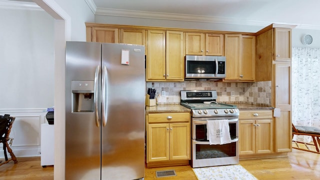 kitchen with stainless steel appliances, light wood-style flooring, visible vents, and backsplash