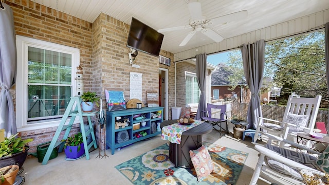 sunroom with brick wall, wooden ceiling, and ceiling fan