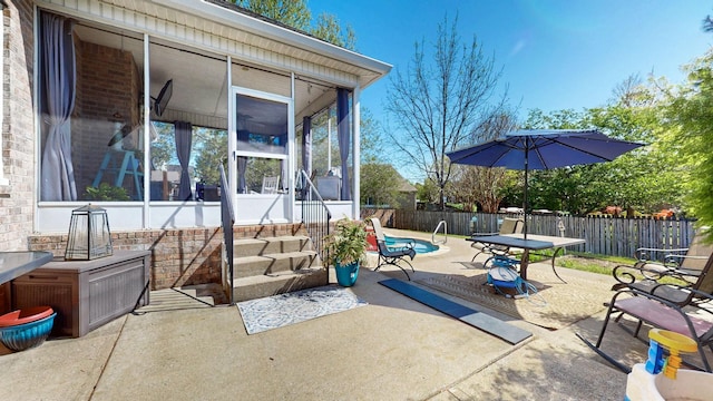 view of patio / terrace featuring fence private yard and a sunroom