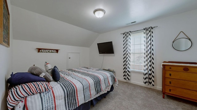 carpeted bedroom with baseboards, vaulted ceiling, and visible vents