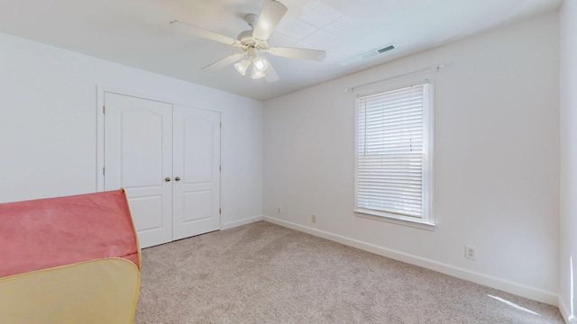 unfurnished room featuring baseboards, visible vents, carpet, and ceiling fan