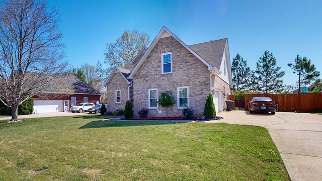 traditional-style house with a front lawn, driveway, fence, brick siding, and an attached garage