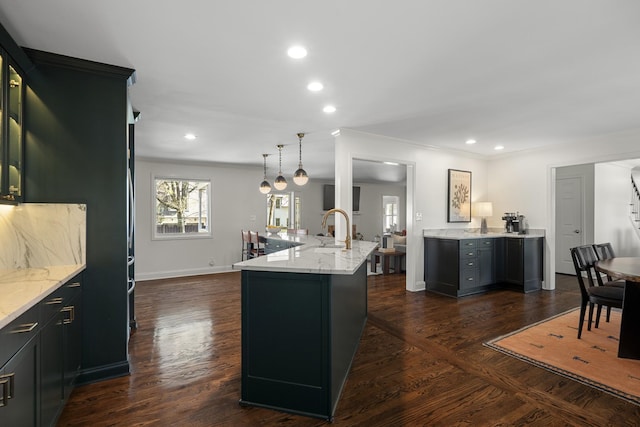 kitchen featuring dark wood-style flooring, a sink, and light stone counters