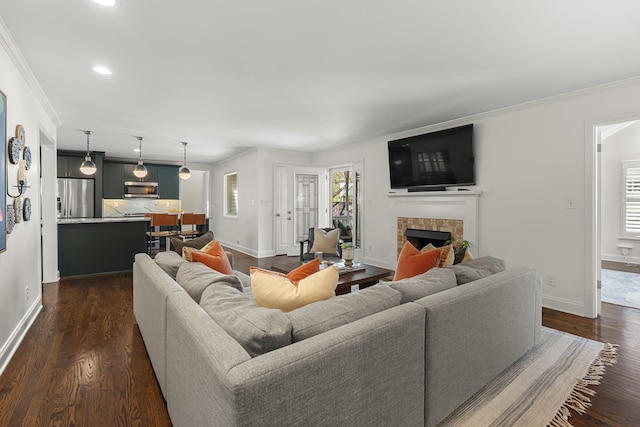 living room featuring crown molding, a fireplace, dark wood-style floors, and a wealth of natural light