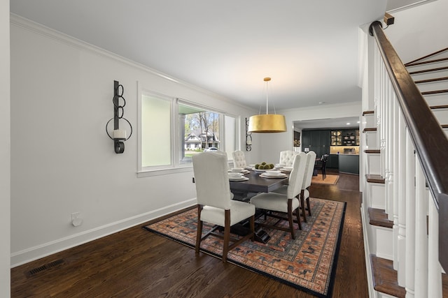 dining area featuring stairs, crown molding, and wood finished floors