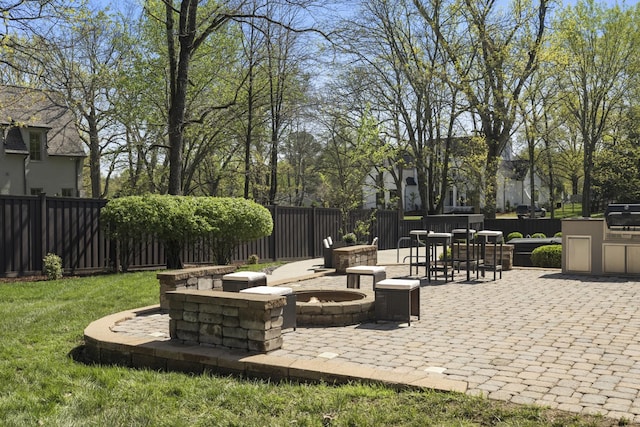 view of patio / terrace featuring area for grilling, fence, and a fire pit
