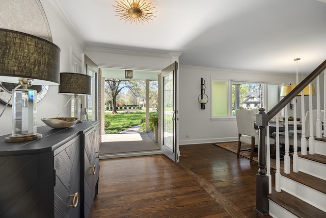 foyer featuring crown molding, baseboards, dark wood-style floors, and stairway