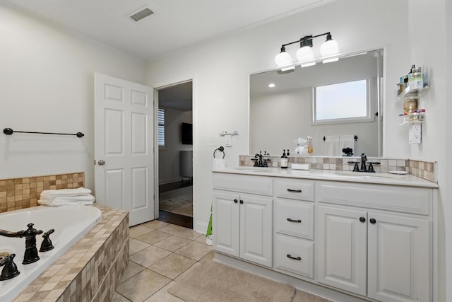 bathroom featuring a garden tub, double vanity, visible vents, and a sink