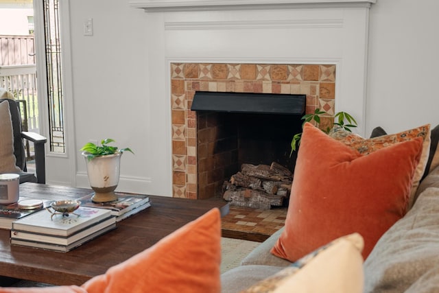living room featuring a tile fireplace and a healthy amount of sunlight
