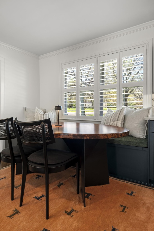 dining space featuring ornamental molding and breakfast area