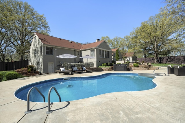view of swimming pool featuring a patio area, a fenced in pool, and fence