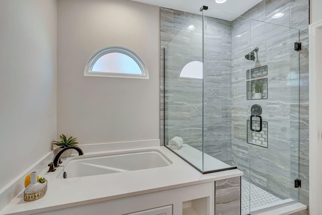 bathroom with a shower stall, a garden tub, and a sink