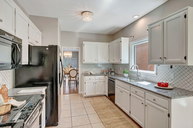kitchen with light tile patterned floors, stainless steel electric stove, light stone countertops, white cabinetry, and dishwasher