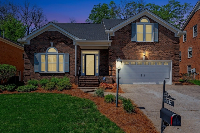 traditional home with an attached garage, a lawn, concrete driveway, and brick siding