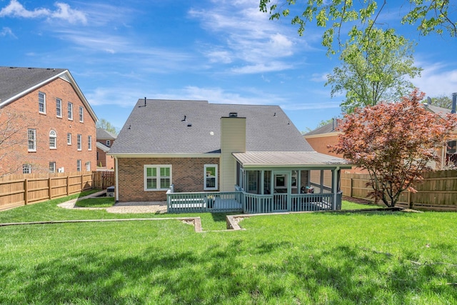 back of property featuring a yard, brick siding, a fenced backyard, and a chimney