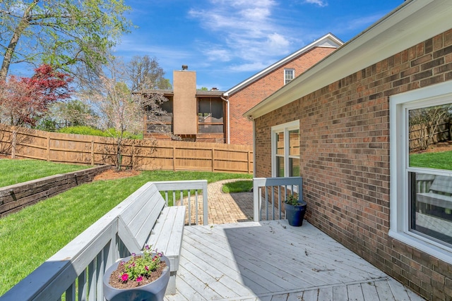 wooden terrace with a yard and fence