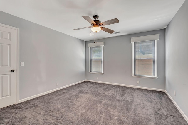 carpeted empty room featuring visible vents, baseboards, and ceiling fan