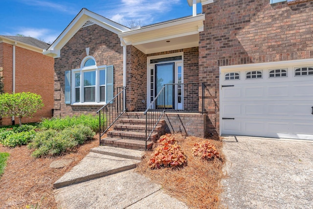 entrance to property with brick siding and a garage
