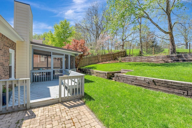 view of yard with fence, a wooden deck, and a sunroom