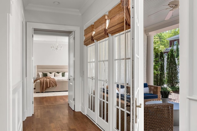 interior space with an inviting chandelier, crown molding, and dark wood finished floors