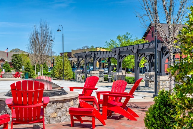 view of property's community featuring a pergola, a patio area, and an outdoor fire pit