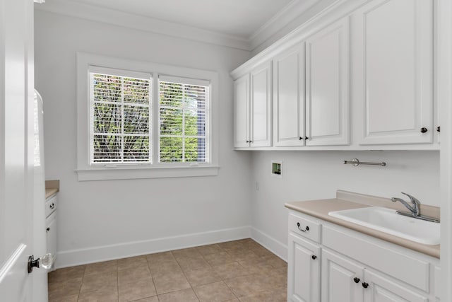 clothes washing area with a sink, baseboards, hookup for a washing machine, and crown molding