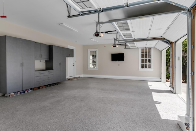 garage featuring a garage door opener and baseboards