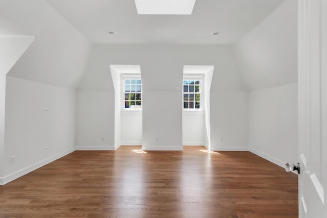 bonus room featuring baseboards, wood finished floors, and lofted ceiling with skylight