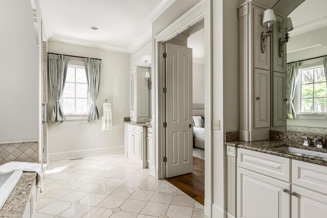 full bath featuring two vanities, a sink, ornamental molding, and tile patterned flooring