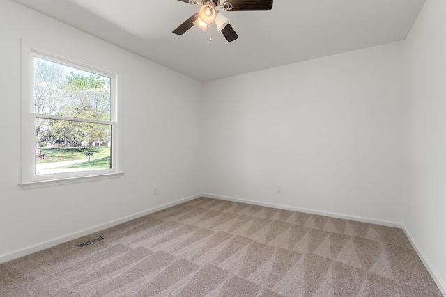 spare room with visible vents, baseboards, a ceiling fan, and light colored carpet