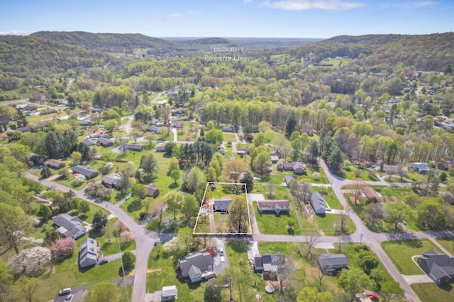 aerial view featuring a wooded view and a mountain view