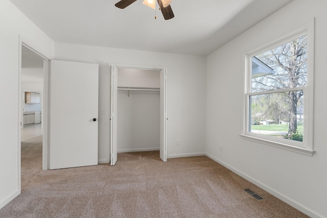 unfurnished bedroom with visible vents, baseboards, multiple windows, and carpet flooring