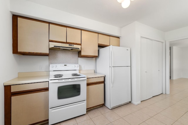 kitchen with under cabinet range hood, light tile patterned floors, light countertops, and white appliances