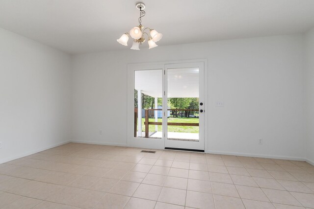 spare room with light tile patterned floors, baseboards, an inviting chandelier, and visible vents