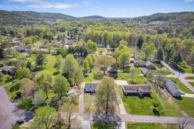 birds eye view of property featuring a wooded view, a residential view, and a mountain view