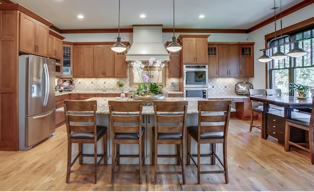 1824 Stryker Pl, Brentwood, TN 37027 - kitchen featuring crown molding, premium range hood, brown cabinetry, and stainless steel appliances