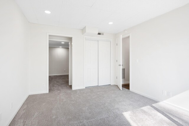unfurnished bedroom featuring recessed lighting, carpet, and visible vents