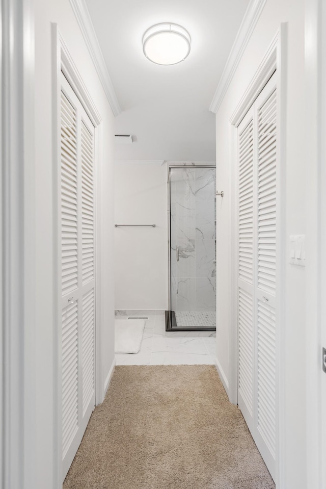 hall with baseboards, ornamental molding, and carpet floors