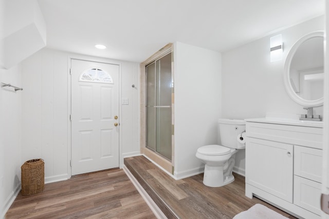 full bath with vanity, toilet, wood finished floors, a stall shower, and baseboards