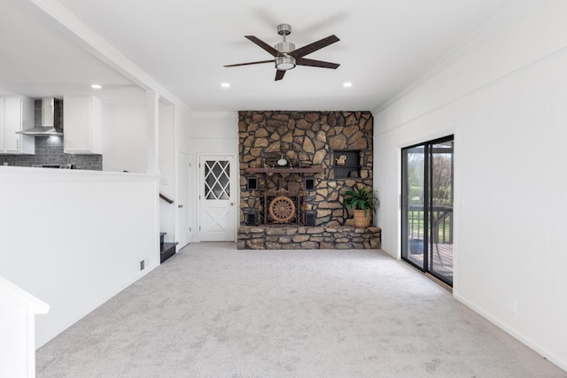 unfurnished living room featuring ceiling fan, ornamental molding, stairway, and carpet floors