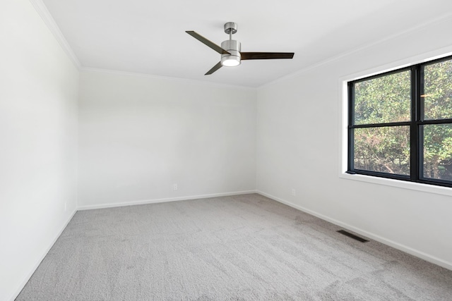 carpeted spare room featuring baseboards, ornamental molding, and visible vents