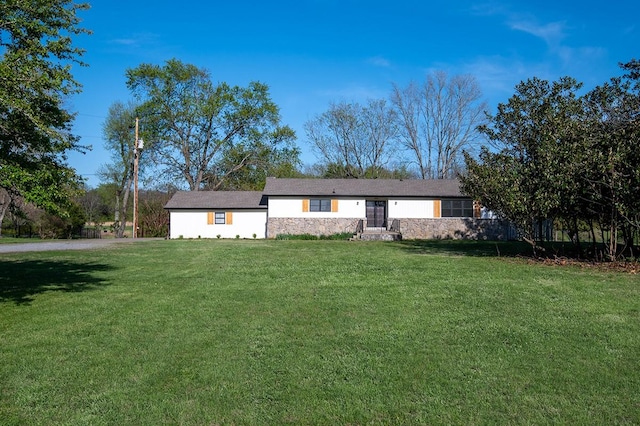single story home with a front lawn and stone siding