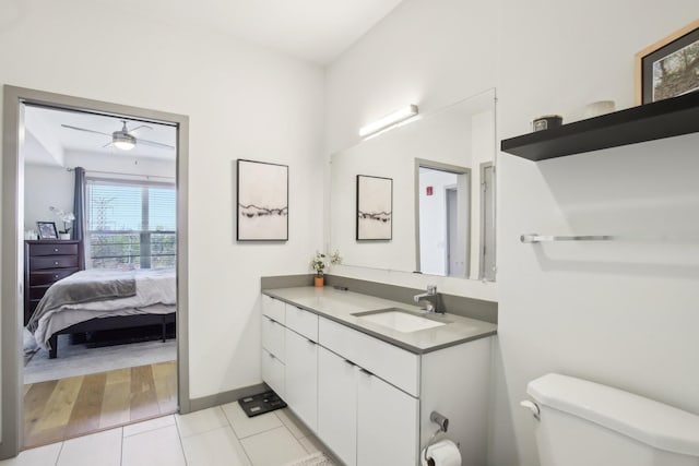 bathroom with ensuite bathroom, baseboards, toilet, vanity, and tile patterned flooring