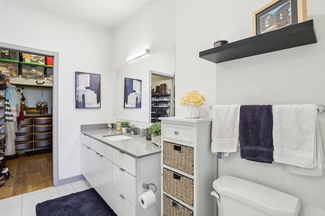 bathroom featuring tile patterned flooring, toilet, vanity, and baseboards