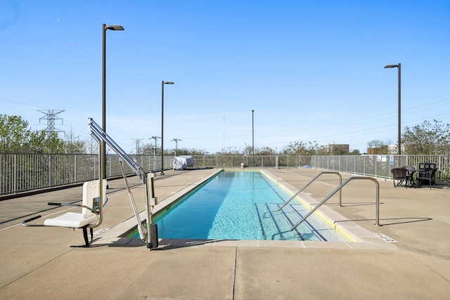 community pool with a patio and fence