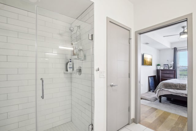 ensuite bathroom with visible vents, a shower stall, ensuite bath, and wood finished floors