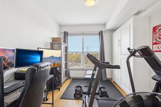 exercise room with visible vents and light wood finished floors