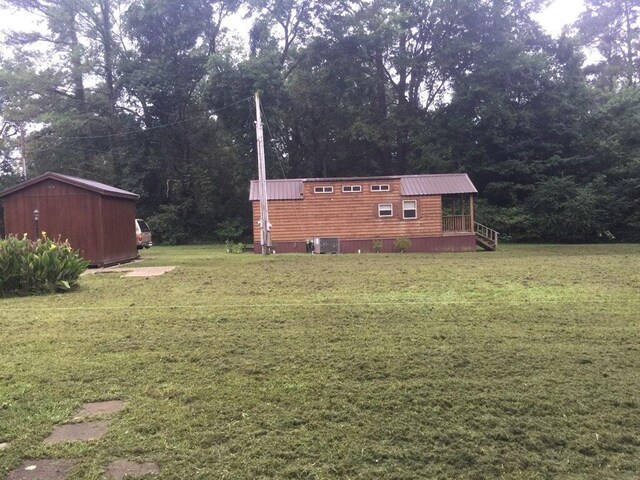 5735 Railroad St, Williston, TN 38076 - view of grassy yard with central AC unit, a view of trees, and a deck