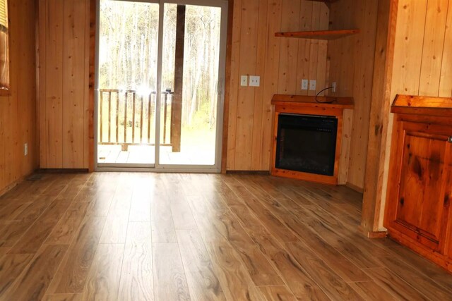 5735 Railroad St, Williston, TN 38076 - unfurnished living room with wooden walls, wood finished floors, and a glass covered fireplace