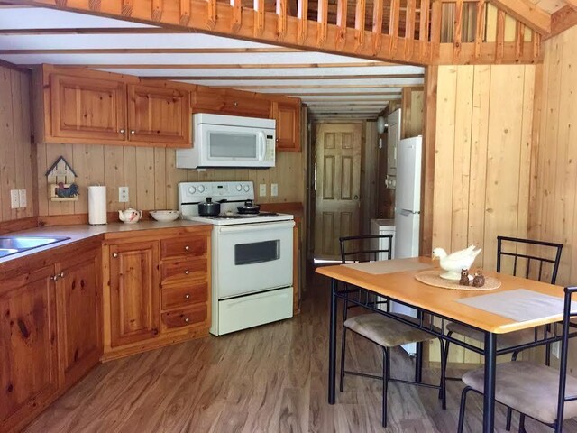 5735 Railroad St, Williston, TN 38076 - kitchen with white appliances, wooden walls, wood finished floors, brown cabinetry, and a sink
